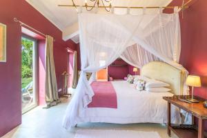 a bedroom with a white bed with a canopy at Espaço Fataca - Sw Alentejano in São Teotónio