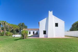 a white church with a grass yard at Espaço Fataca - Sw Alentejano in São Teotónio