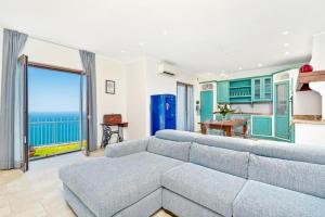a living room with a couch and a view of the ocean at Orizzonte Damare in Volastra
