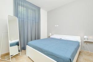 a white bedroom with a bed and a mirror at Orizzonte Damare in Volastra