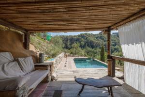 a patio with a couch and a swimming pool at La Isla Verde in Els Hostalets