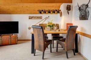a dining room with a table with chairs and a tv at Feldbergstern in Feldberg