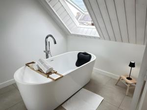 a white bath tub in a bathroom with a skylight at Ker Mam - Belle-Ile in Sauzon +26 photos