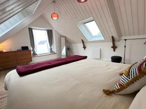 a bedroom with a large white bed in a attic at Ker Mam - Belle-Ile in Sauzon