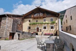 a table and chairs in front of a building at Bertollhof Apfelerlebnis in Silandro