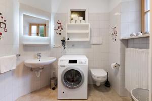 a white bathroom with a washing machine and a sink at Bertollhof Apfelerlebnis in Silandro +24 photos
