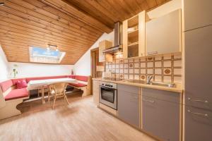 a kitchen with a table and a dining room at Residence Kronstein - Fewo 8 in Tesimo
