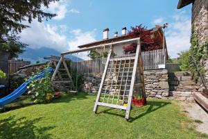 a garden with a ladder and a playground at Bertollhof Apfelerlebnis in Silandro