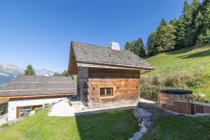 a stone house on a hill with a yard at Mazot de la Pointe Percée in Combloux