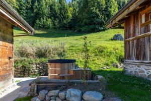 a barrel sitting outside of a building next to a field at Mazot de la Pointe Percée in Combloux +5 photos