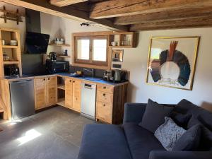 a living room with a couch and a kitchen at Mazot de la Pointe Percée in Combloux
