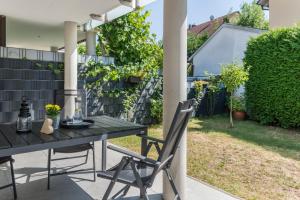 a table and chairs on a patio with a yard at Fewo Köse in Uhldingen-Mühlhofen