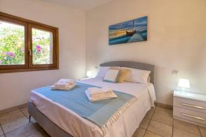 a bedroom with a bed with two towels on it at Villa Amalthea - sea view-wellness in Costa Paradiso