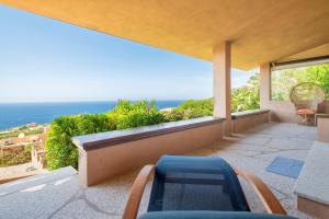 a balcony with chairs and a view of the ocean at Villa Amalthea - sea view-wellness in Costa Paradiso