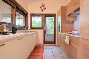 a kitchen with white cabinets and a window and a door at Villa Amalthea - sea view-wellness in Costa Paradiso +22 photos