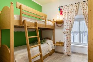 a bunk bed in a room with green walls at L'antica corte apt Angelina in Levico Terme