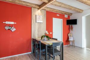 a dining room with red walls and a table with chairs at L'antica corte apt Angelina in Levico Terme