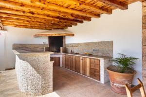 an open kitchen with wooden ceilings and a counter top at Casa Es Pins in Santa Eularia des Riu