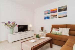 a living room with a couch and a tv at Apartamento Cañada Honda Conil in Conil de la Frontera