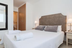 a white bedroom with a large white bed with two pillows at Apartamento Cañada Honda Conil in Conil de la Frontera +36 photos