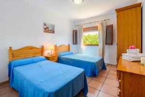 a bedroom with two beds and a window at Casa Es Pins in Santa Eularia des Riu +17 photos