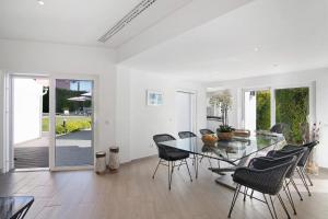 a dining room with a glass table and chairs at Pine Lodge in Vilamoura