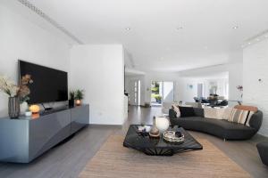 a living room with a couch and a tv at Pine Lodge in Vilamoura