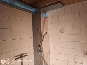 a shower in a bathroom with white tiled walls at Ferienhaus Weiler im Allgäu in Weiler in Allgau +35 photos