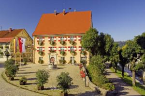 a large yellow building with a red roof at Ferienhaus Weiler im Allgäu in Weiler in Allgau