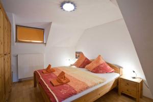 a bedroom with a bed with orange pillows on it at Ferienhaus Weiler im Allgäu in Weiler in Allgau