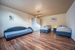 two beds in a room with wooden floors at Ferienwohnung Bartölke in Bockenem