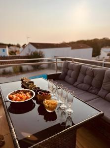 a table with wine glasses and food on a balcony at Villa des sablons, piscine chauffée in La Tranche-sur-Mer