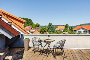 a patio with two chairs and a table on a deck at Appartement Männerleben in Harztor