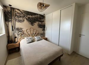a bedroom with a white bed and a fan at Villa des sablons, piscine chauffée in La Tranche-sur-Mer +10 photos