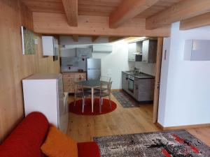 a small kitchen with a table and a refrigerator at Monolocale Carfon in Canale dʼAgordo +2 photos