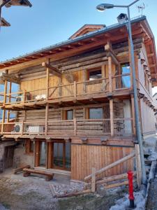 a wooden house with a deck and a fire hydrant at Monolocale Carfon in Canale dʼAgordo