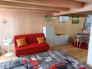 a living room with a red couch and a table at Monolocale Carfon in Canale dʼAgordo
