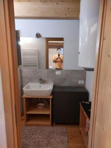a man taking a picture of himself in a bathroom mirror at Monolocale Carfon in Canale dʼAgordo
