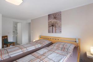 a bedroom with two beds and a picture on the wall at Ferienwohnung Selbecke in Kirchhundem +20 photos