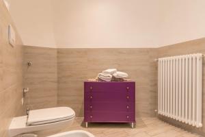 a bathroom with a toilet and a purple cabinet at Casa di Ada in Segonzano