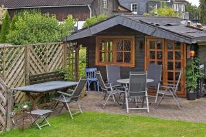 a picnic table and chairs in front of a cabin at Ferienwohnung Selbecke in Kirchhundem