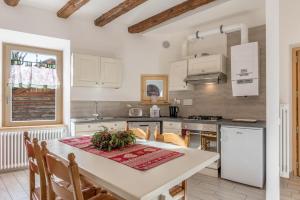 a kitchen with a white table with chairs and a table sidx sidx sidx at Casa di Ada in Segonzano