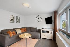 a living room with a couch and a clock on the wall at Ferienwohnung Selbecke in Kirchhundem