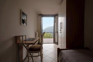 a bedroom with a desk and a bed and a window at Stella del Garda 2 con terrazza in Tignale