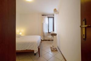 a bedroom with a bed and a table and a window at Stella del Garda 2 con terrazza in Tignale