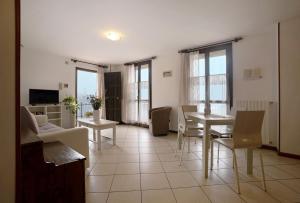 a living room with a table and chairs at Stella del Garda 2 con terrazza in Tignale