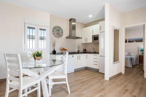 a kitchen and dining room with a glass table and chairs at Casa Orilla Sur A in El Palmar