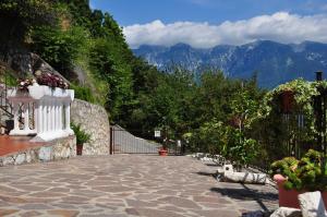 a stone walkway with potted plants and mountains in the background at Stella del Garda 2 con terrazza in Tignale