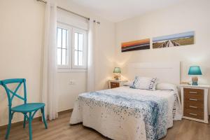a bedroom with a bed and a chair and a window at Casa Orilla Sur A in El Palmar +19 photos