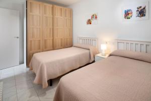 a bedroom with two beds and a sliding door at Casa Santo front beach in Cala del Moral